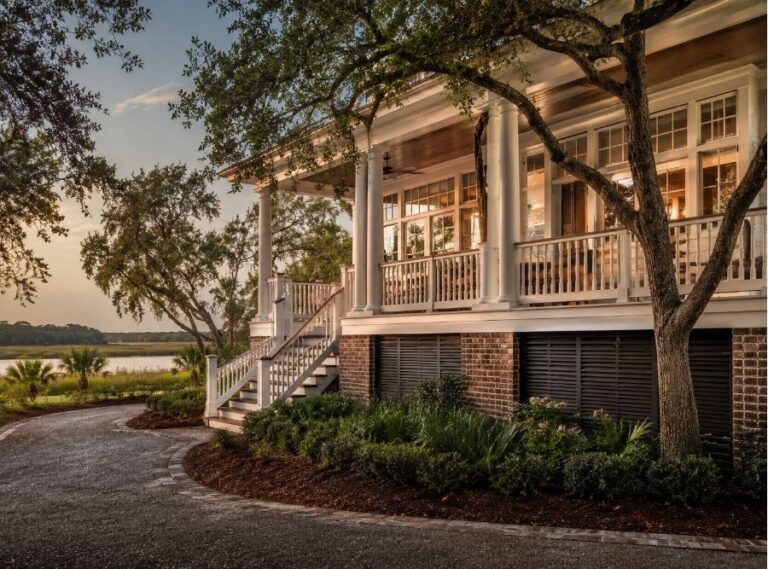 Luxury Hilton Head Island coastal home in Wexford or Long Cove style neighborhood, elegant Lowcountry architecture with elevated foundation and mature live oak trees, warm humid coastal atmosphere, upscale second-home aesthetic, marshfront environment with soft coastal light, subtle indication of home performance and crawl-space protection